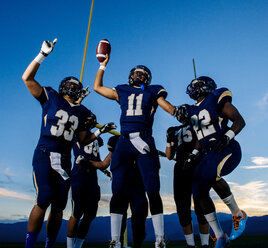 teenage-and-young-male-american-football-team-celebrating-ISF10472